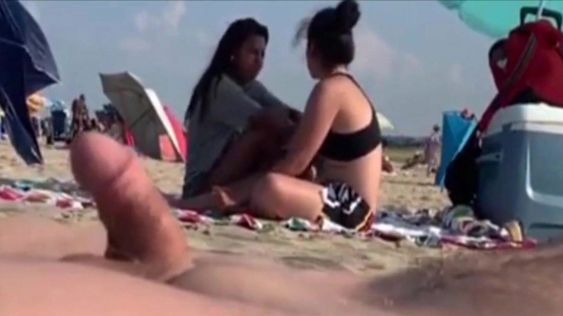 két lány egy nyilvános strandon figyeli az ember rúdját, két gála, aki a gombomhoz néz, elengedte őket ..